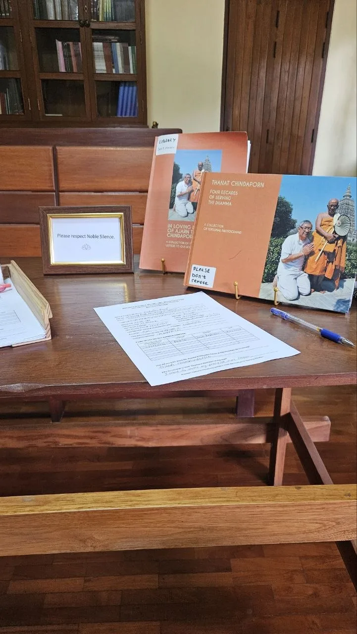 The registration desk of a vipassana retreat in Thailand, with books about Ajahn Tong
